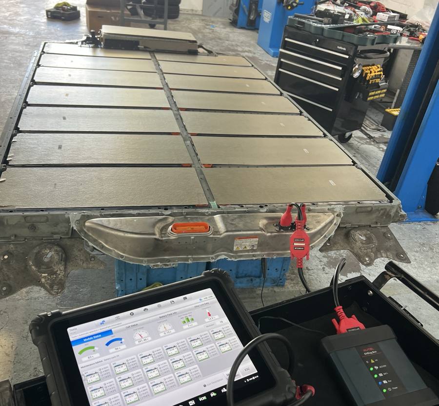 Battery pack closed and connected to an Autel diagnostic tablet showing all modules balanced